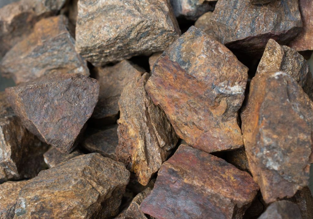 Trozos de mineral de cobre con vetas rojizas, doradas y grises